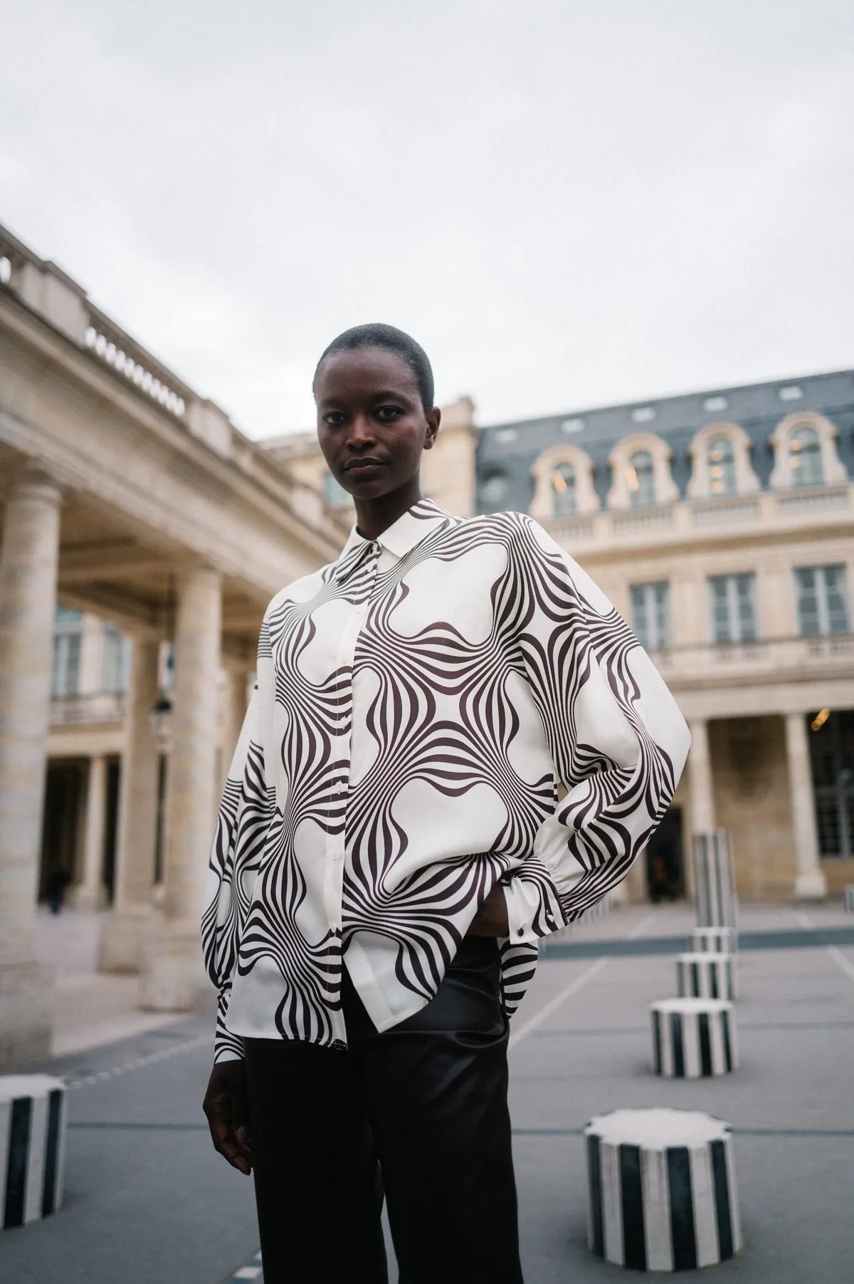 Model in schwarz-weißer Op-Art-Bluse im Palais Royal – Herzens Herbst/Winter 2026