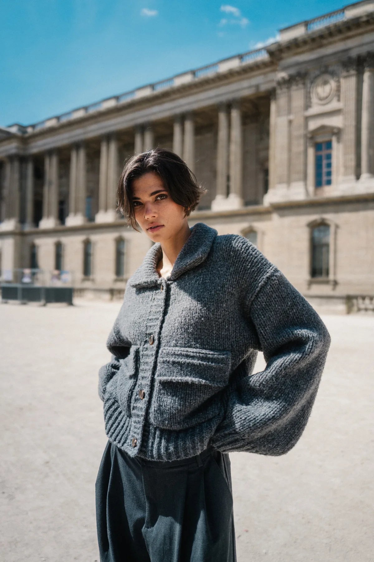 Model in grauer Strickjacke vor dem Louvre – Herzens Herbst/Winter 2026