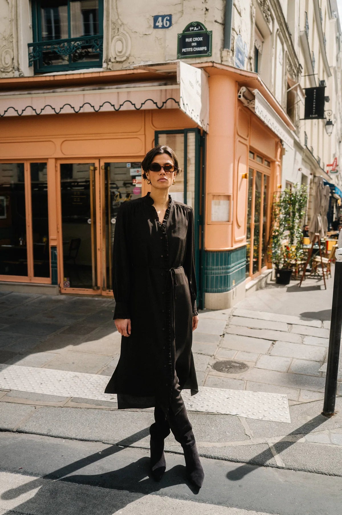 Model in schwarzem Look vor einem Pariser Café – Herzens Herbst/Winter 2026