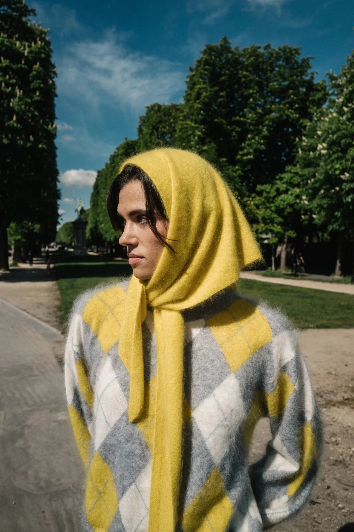 Model mit gelbem Cashmere-Tuch und Argyle-Pullover in einem Pariser Park – Herzens Herbst/Winter 2026
