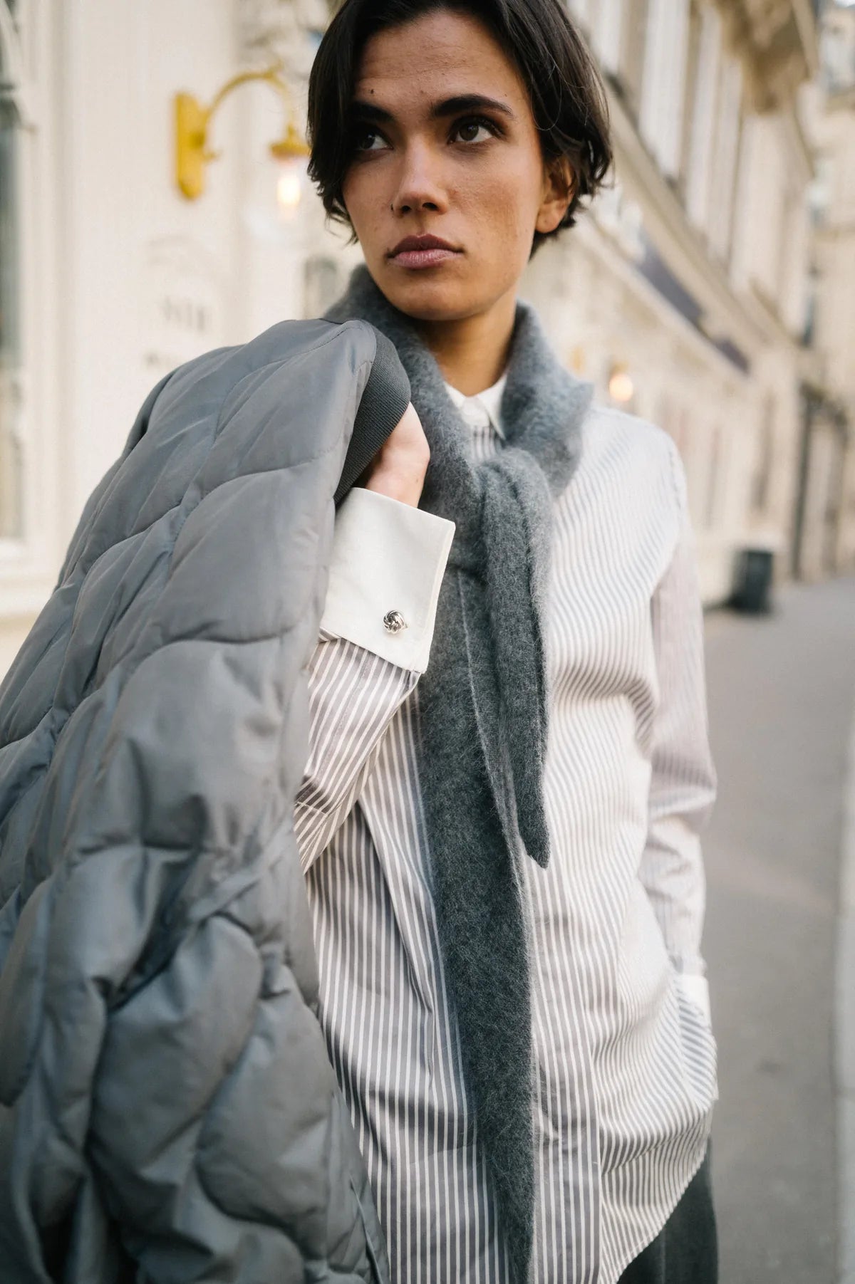 Model mit Steppjacke, grauem Strickschal und gestreifter Bluse – Herzens Herbst/Winter 2026