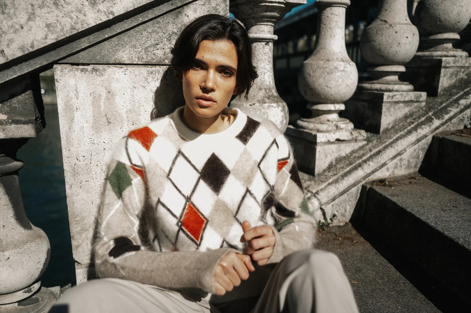 Model im Argyle-Pullover sitzend auf einer Steintreppe in Paris – Herzens Herbst/Winter 2026