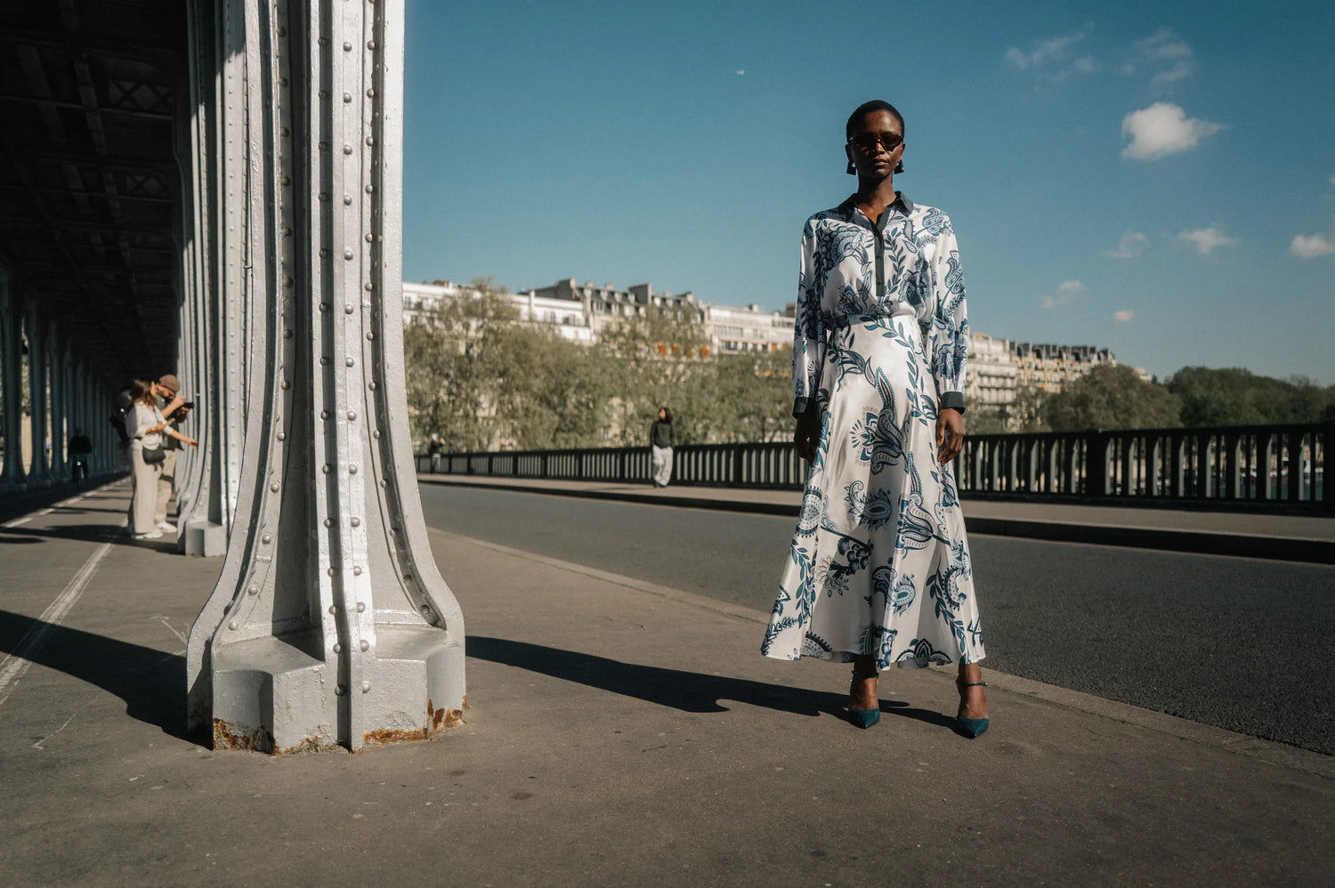 Model im blau-weißen Paisley-Kleid unter der Pont de Bir-Hakeim – Herzens Herbst/Winter 2026