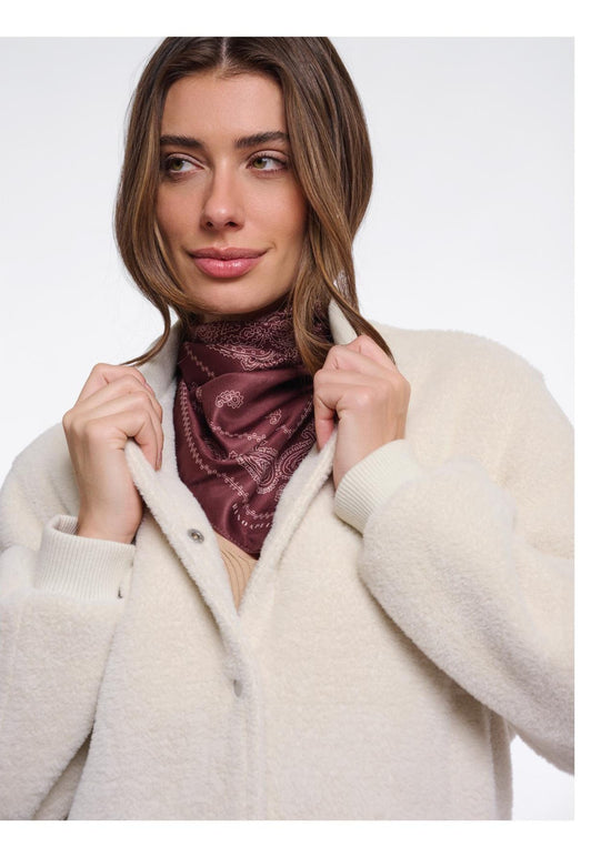 Model in cremefarbener Teddyjacke mit bordeauxfarbenem Halstuch – Rino & Pelle Herbst/Winter 2026