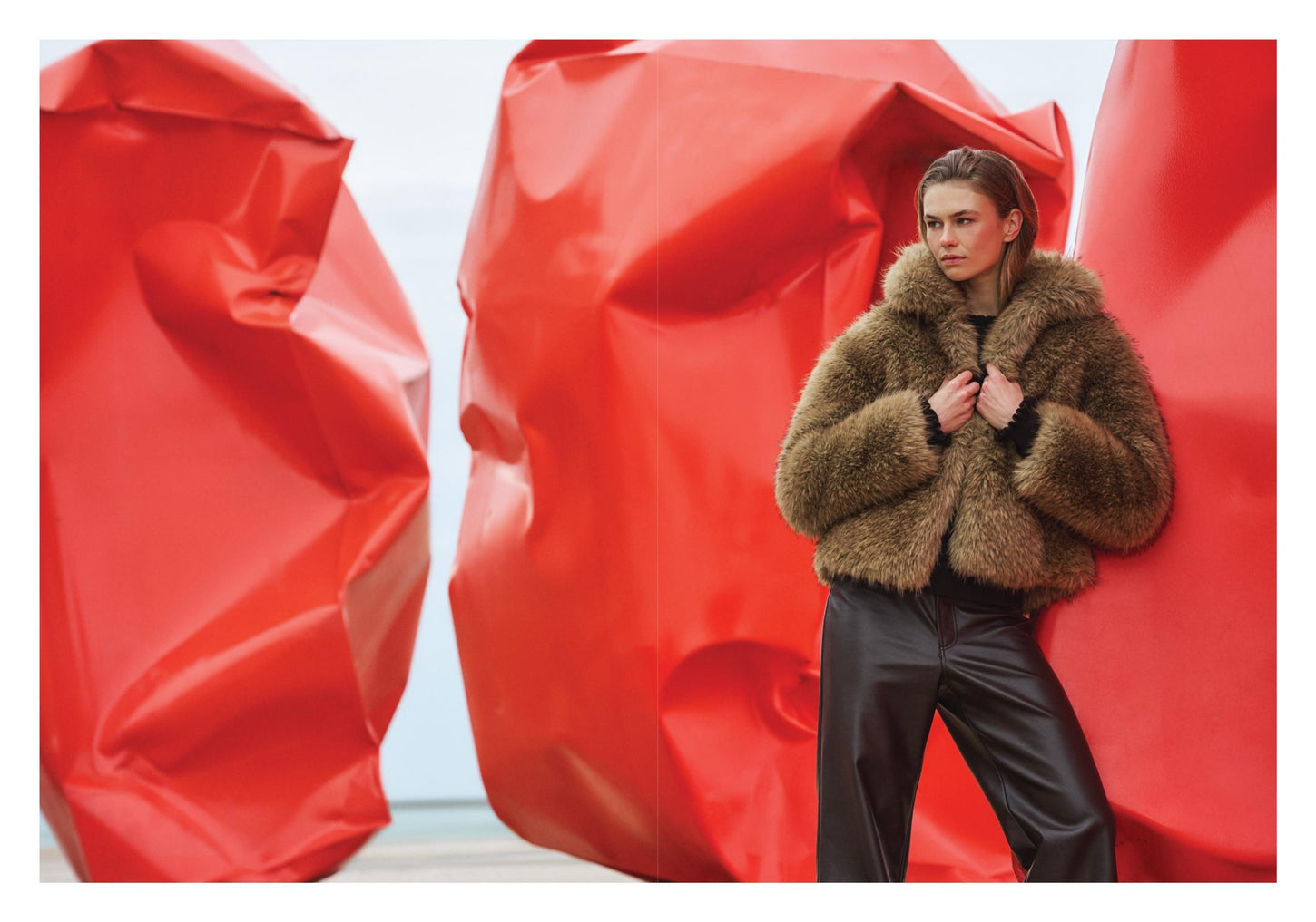 Model in brauner Jacke in Fell-Optik und Lederlook-Hose vor roter Skulptur – Rino & Pelle Herbst/Winter 2026
